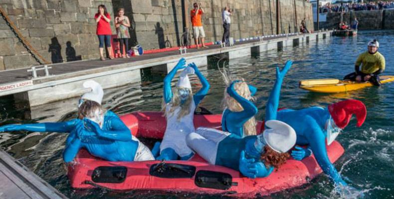 Ladies painted as smurfs paddling in St Peter Port Harbour during Harbour Carnival