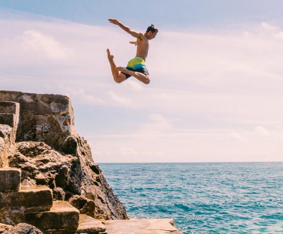 boy jumping into sea