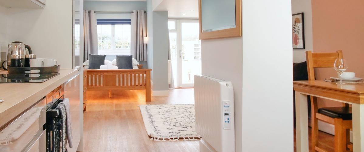 view to end of Studio Apartment showing a kitchen in foreground and large bed in background