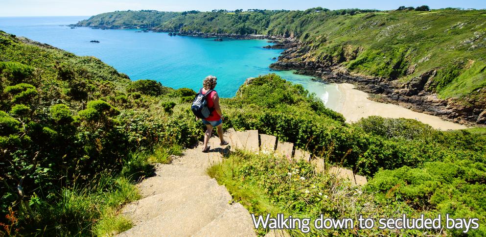 Lady walking down cliff paths to bay