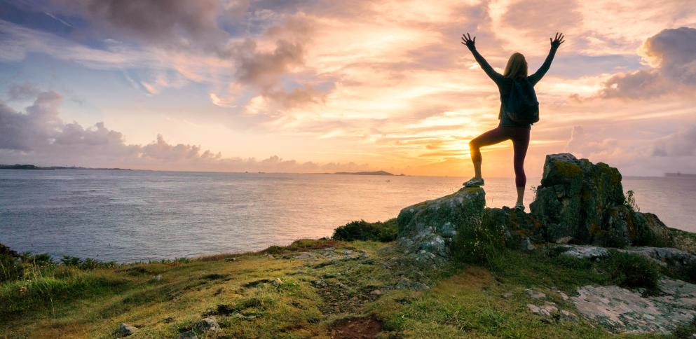 woman standing on rock at dawn