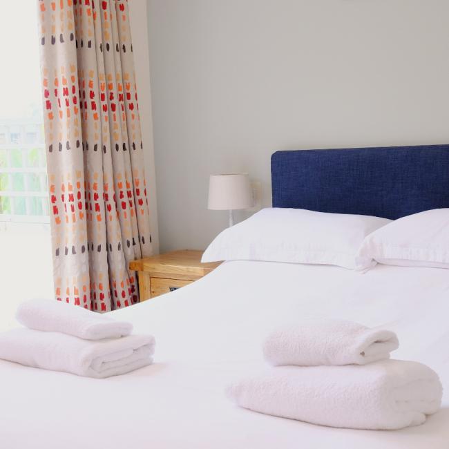 bed with blue headboard and bright curtains