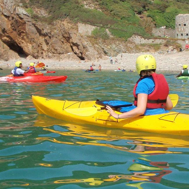 Person kayaking in sea at Fermain Beach in Guernsey, near to The Ellingham self catering cottages