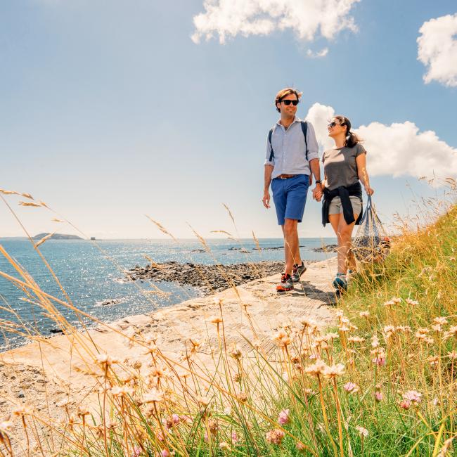 couple walking on the north coast in Guernsey